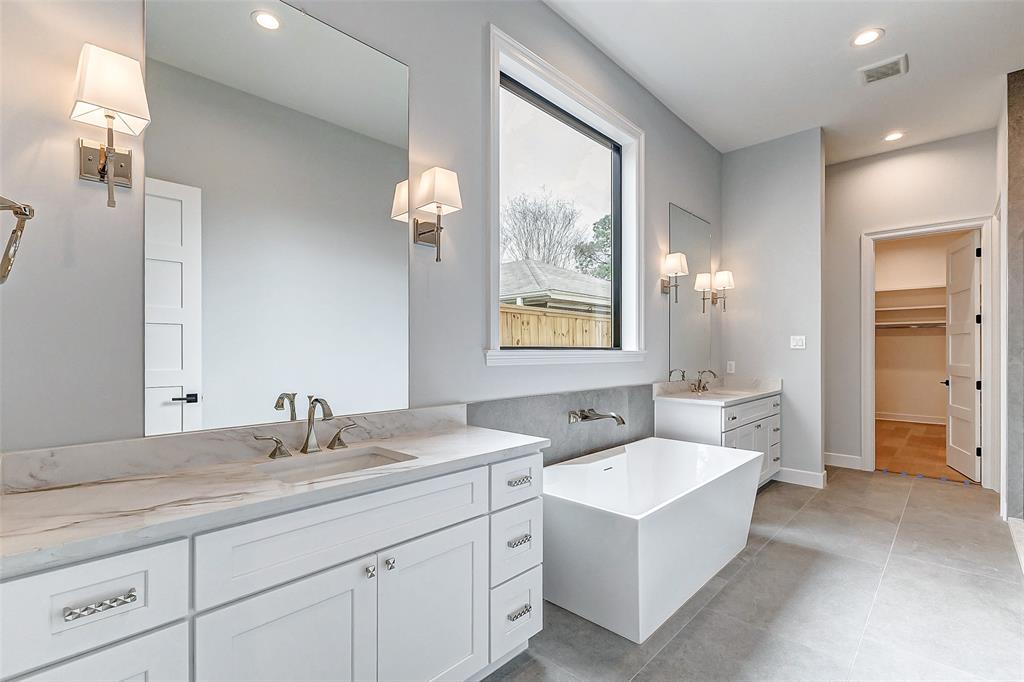 Maribelle bathroom with freestanding tub, stone surfaces and abundant natural light