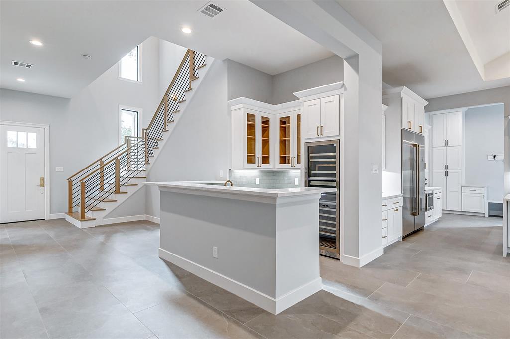 Open interior with wood floors, stair detailing and a built-in bar